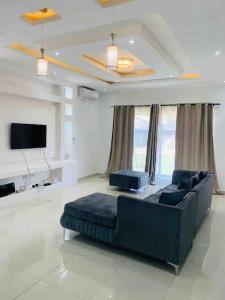 een woonkamer met een bank en een flatscreen-tv bij Executive 4 bedroom house with 4 beds . in Lusaka