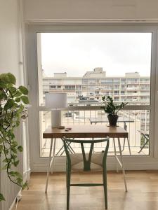 a table with a lamp in front of a window at Chambre tout confort, spacieuse, calme et lumineuse avec balcon in Paris