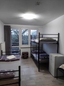Ośrodek Wypoczynkowo-Hotelowy PRZĄŚNICZKA في لودز: غرفة بها ثلاثة أسرة بطابقين ونوافذ