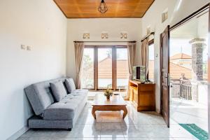 ein Wohnzimmer mit einer Couch und einem Tisch in der Unterkunft Rumah Akira Seminyak in Seminyak