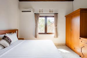 ein Schlafzimmer mit einem Bett und einem Fenster in der Unterkunft Rumah Akira Seminyak in Seminyak + 13 Fotos