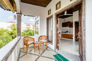 einen Balkon mit einem Tisch und Stühlen sowie eine Küche in der Unterkunft Rumah Akira Seminyak in Seminyak
