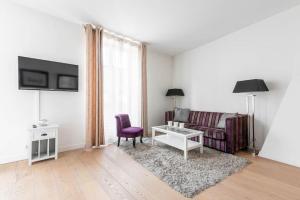 ein Wohnzimmer mit einem Sofa und einem Tisch in der Unterkunft Appartement Vintage Le Bon Marché - III in Paris