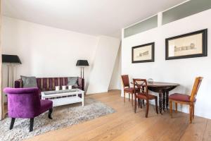 ein Wohnzimmer mit einem lila Sofa und einem Tisch in der Unterkunft Appartement Vintage Le Bon Marché - III in Paris