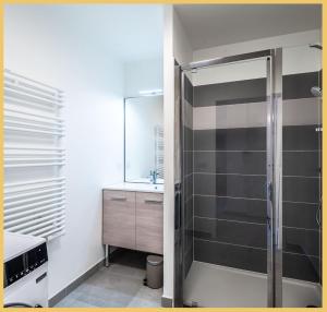 ein Bad mit einer Dusche und einem Waschbecken in der Unterkunft Appartement T2 Sublime Beaumont in Beaumont