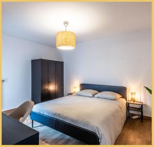 ein Schlafzimmer mit einem großen Bett und einem schwarzen Schrank in der Unterkunft Appartement T2 Sublime Beaumont in Beaumont