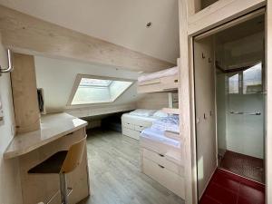 a small room with two beds and a window at Duplex skis aux pieds centre village - 6 couchages - 2 salles de bain in La Clusaz