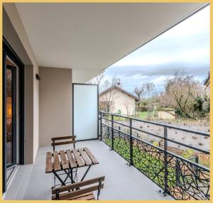 a balcony with a table and benches and a view at Appartement T2 Sublime Beaumont in Beaumont