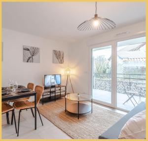 a living room with a table and chairs and a couch at Appartement T2 Sublime Beaumont in Beaumont