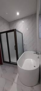 baño con una gran bañera blanca y ventanas en Executive 4 bedroom house with 4 beds . en Lusaka