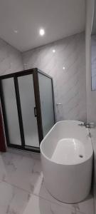a bathroom with a large white tub and windows at Executive 4 bedroom house with 4 beds . in Lusaka