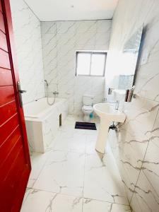 La salle de bains est pourvue d'un lavabo, d'une baignoire et de toilettes. dans l'établissement Executive 4 bedroom house with 4 beds ., à Lusaka
