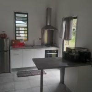 uma cozinha com uma mesa no meio em Tiny House Moorea Haylee em Papetoai