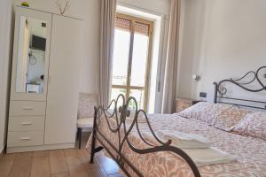 1 dormitorio con 1 cama con tocador y ventana en At aldina's House en Soveria Mannelli