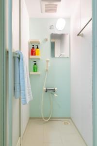 ein Bad mit einer Dusche mit einem Schlauch in der Unterkunft グランシャーギ in Osaka