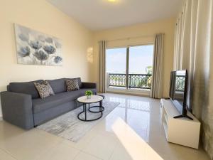 a living room with a couch and a tv at Bab Al Bahr Residence - Blue Collection Holiday Homes in Ras al Khaimah