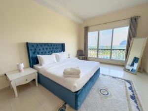 a bedroom with a large bed and a large window at Bab Al Bahr Residence - Blue Collection Holiday Homes in Ras al Khaimah