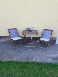 a table and two chairs sitting next to a wall at Bei Hempels in Breitscheid