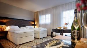 イェレニャ・グラにあるPałac na Wodzie Hotel & SPAのベッド2台とテーブルが備わるホテルルームです。