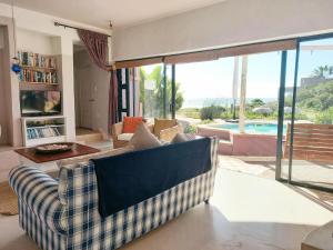 a living room with a couch and a pool at Absolute Beach Accommodation in Stompneusbaai