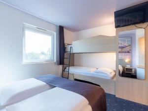 ein Hotelzimmer mit 2 Betten und 1 Etagenbett in der Unterkunft B&B Hotel Mannheim in Mannheim