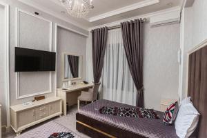 Shaxzoda Elite Hotel في سمرقند: غرفة في الفندق مع غرفة نوم مع سرير ومكتب