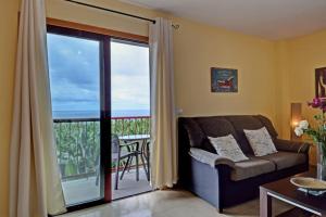 a living room with a couch and a balcony at Belair Tazacorte in Tazacorte