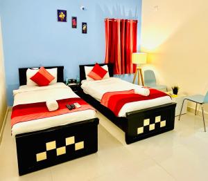 2 camas en una habitación de hotel con en HOTEL NAMAHA, en Shamshabad