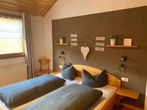 的住宿－Vogelbacher Hof - Dachsberg im Südschwarzwald，一间卧室配有两张带蓝色枕头的床