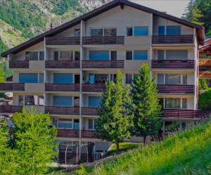 an apartment building with balconies on a mountain at Studio Mundizia in Zermatt