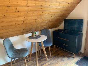 a room with a table and two chairs and a tv at Vogelbacher Hof - Dachsberg im Südschwarzwald 