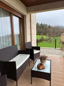 a patio with two chairs and a table on a porch at Casa do Gaspar in Ribeira de Pena