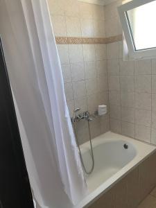 a bathroom with a bath tub with a shower curtain at Luxury Apartment 2 in Alexandroupoli