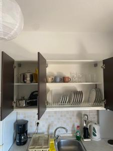 a kitchen with a sink and shelves with dishes at Luxury Apartment 2 in Alexandroupoli