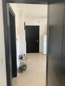 un pasillo con una puerta negra y una mesa en Luxury Apartment 2 en Alexandroupolis