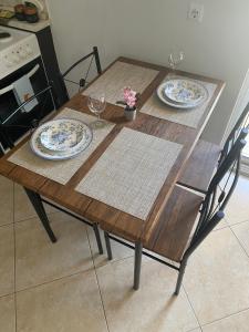 a wooden table with two plates and two chairs at Luxury Apartment 2 in Alexandroupoli