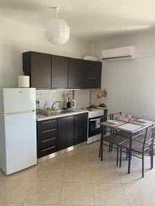 a kitchen with a white refrigerator and a table at Luxury Apartment 2 in Alexandroupoli
