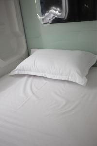 a white bed with white sheets and a pillow at CAPS LOCK in (( Turksib ))
