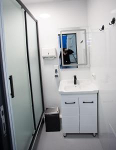 La salle de bains blanche est pourvue d'un lavabo et d'un miroir. dans l'établissement CAPS LOCK, à Turksib