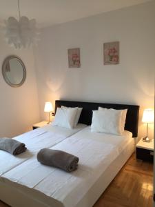 un grande letto bianco con due cuscini sopra di Apartments Papalinna a Malinska