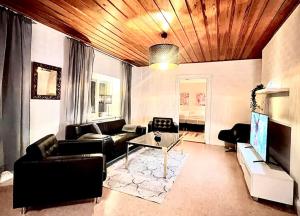 una sala de estar con muebles de cuero y techo de madera. en Centralt Skinnskatteberg 2 sovrum, en Skinnskatteberg