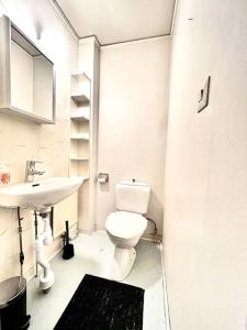 een witte badkamer met een toilet en een wastafel bij Centralt Skinnskatteberg 2 sovrum in Skinnskatteberg