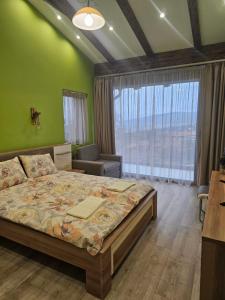 1 dormitorio con cama y pared verde en Relax Srednogorska Panorama, en Smolsko