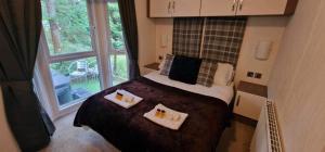 a small bedroom with a bed and a window at Jax Retreat hot tub and free golf in Felton