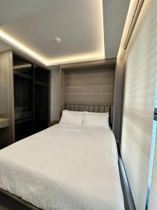 2 beds bangkok center max 6 في Klong Toi: غرفة نوم مع سرير أبيض كبير في غرفة