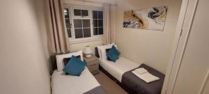 a small room with two beds and a window at Charming 3 Bed house Family and Long-stay Discount in Maidenhead