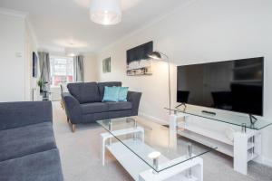 a living room with a couch and a flat screen tv at Charming 3 Bed house Family and Long-stay Discount in Maidenhead