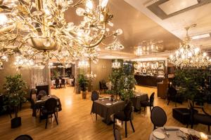 a dining room with tables and chandeliers at Baltvilla in Baltezers