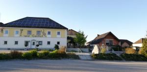 ein großes weißes Gebäude mit Sonnenkollektoren auf dem Dach in der Unterkunft Frühstückspension Wahl in Ruprechtshofen
