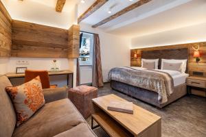 una camera d'albergo con un letto e un divano di Hotel Zehnerkar & Hotel Obertauern a Obertauern